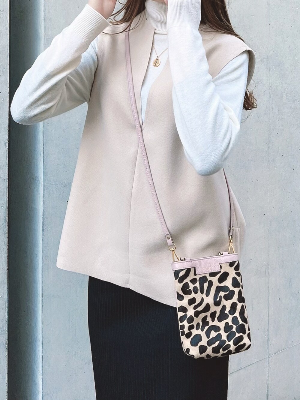 ブラック系のスカート、ホワイト系のブーツ、その他のバッグを着用したレディースの冬コーディネートの4枚目の写真