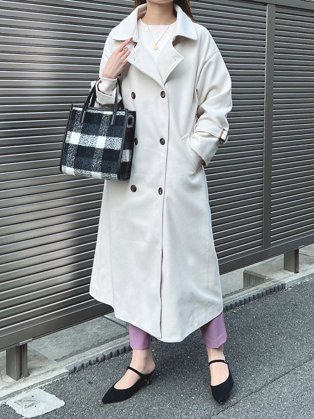 ホワイト系のトレンチコート、ホワイト系のニット/セーター、ブラック系のパンプスを着用したレディースの秋コーディネートの3枚目の写真