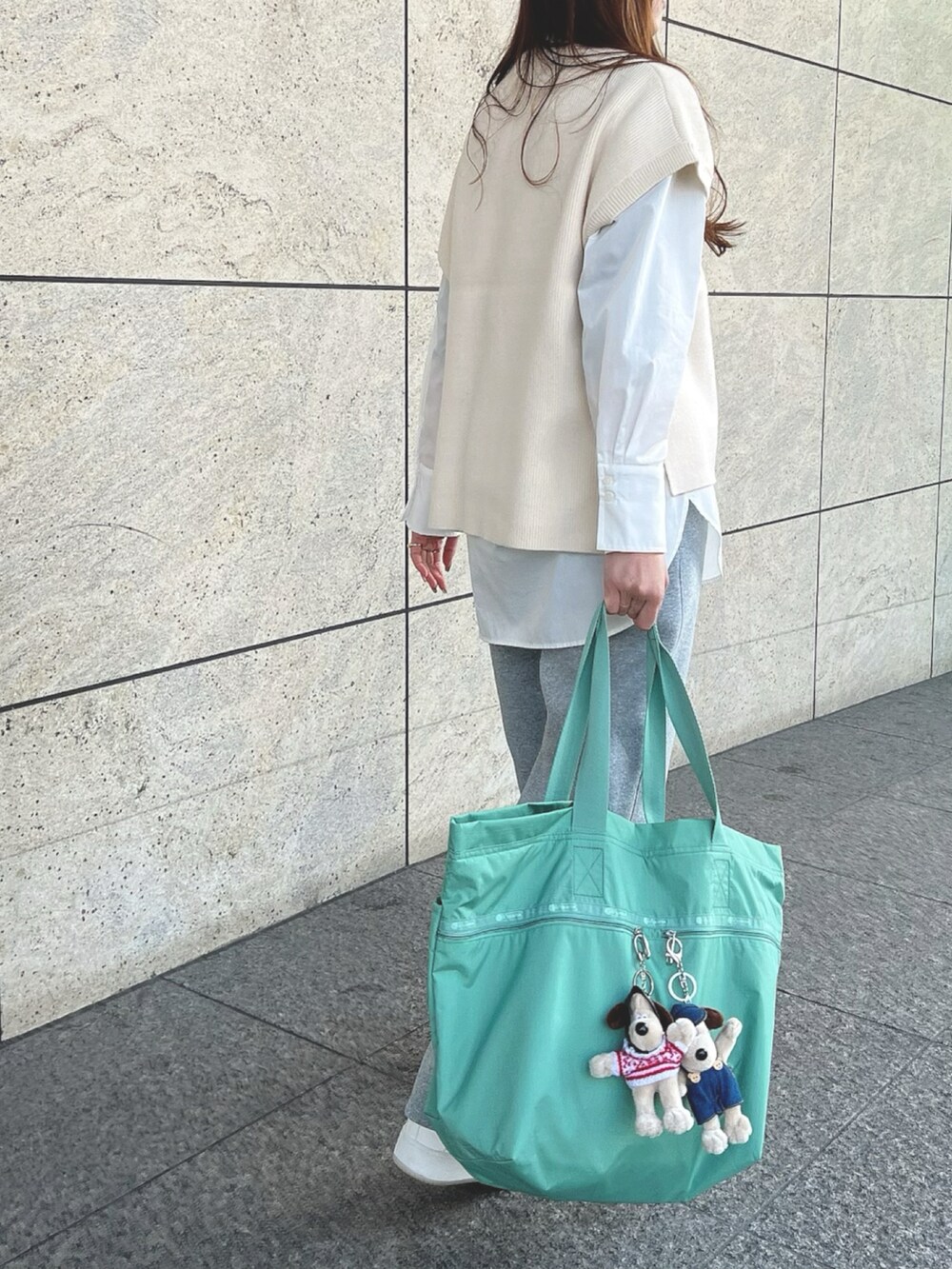 グリーン系のトートバッグを着用したレディースの冬コーディネートの2枚目の写真