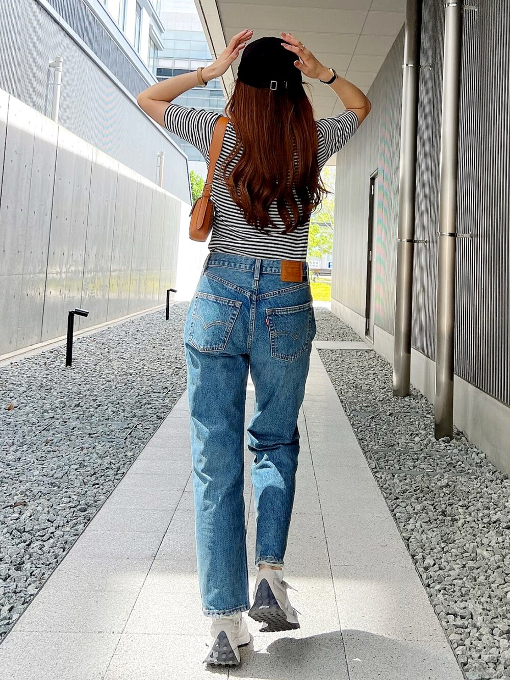 ブルー系のデニムパンツ、ブラック系のTシャツ/カットソーを着用したレディースの秋コーディネートの2枚目の写真