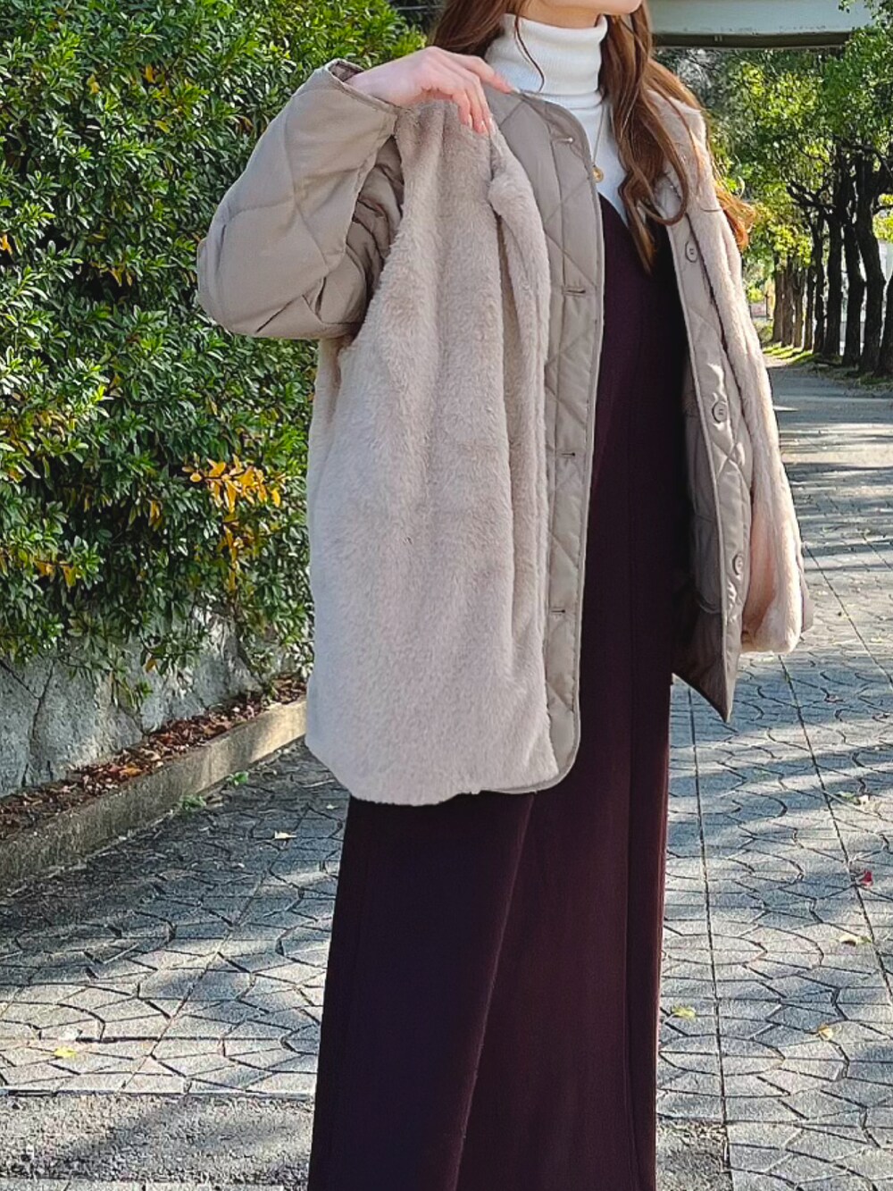 ブラウン系のダウンジャケット/コート、ブラウン系のワンピース/ドレス、ブラウン系のブーツを着用したレディースの冬コーディネートの2枚目の写真