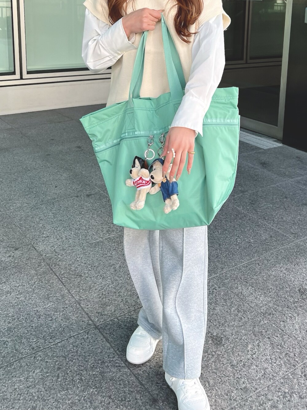 グリーン系のトートバッグを着用したレディースの冬コーディネートの3枚目の写真