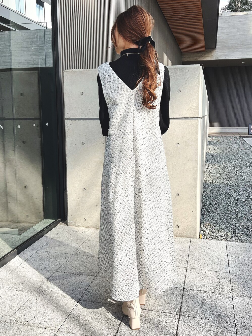 ホワイト系のワンピース、ホワイト系のブーツ、ブラック系のニット/セーターを着用したレディースの冬コーディネートの3枚目の写真