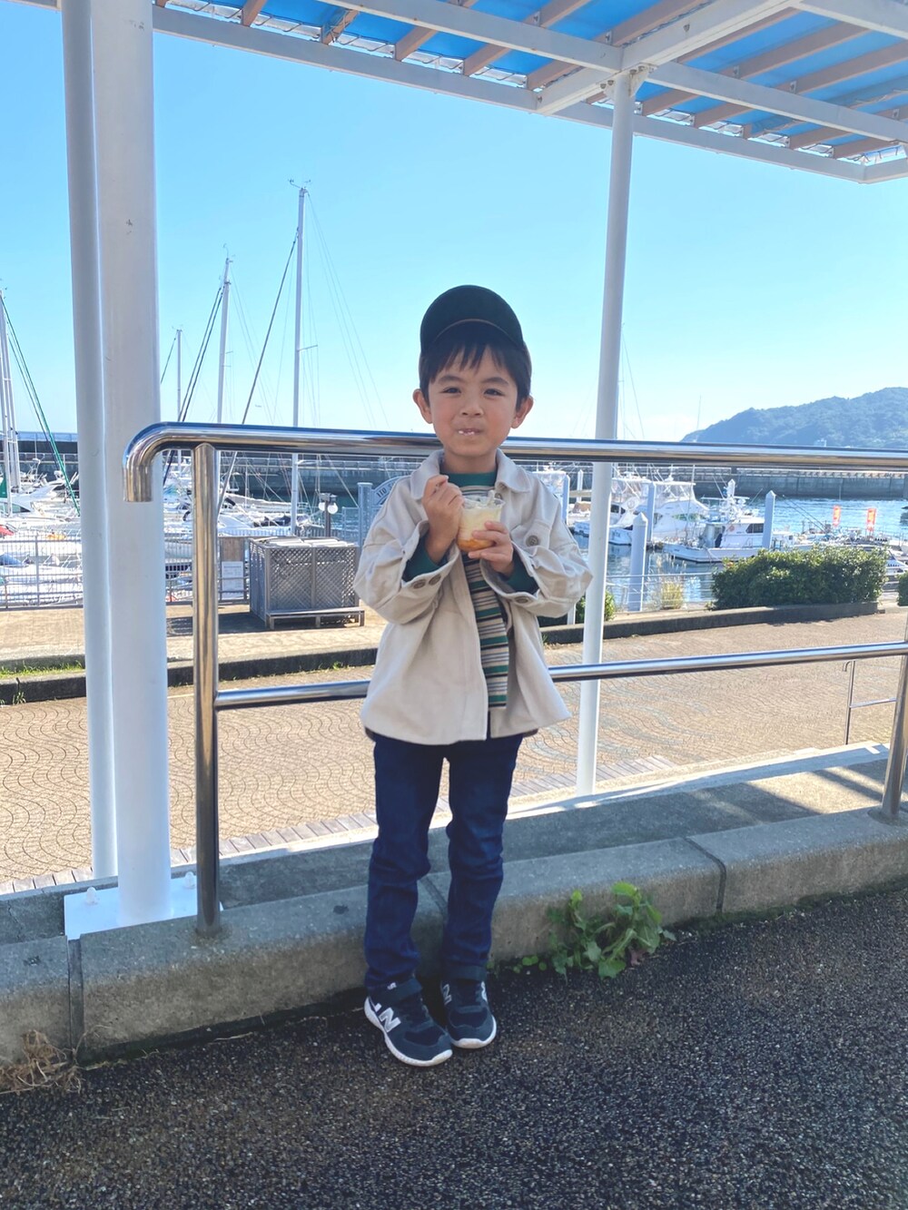 ホワイト系のブルゾン、ブルー系のデニムパンツ、グリーン系のTシャツ/カットソーを着用したキッズの秋コーディネートの3枚目の写真