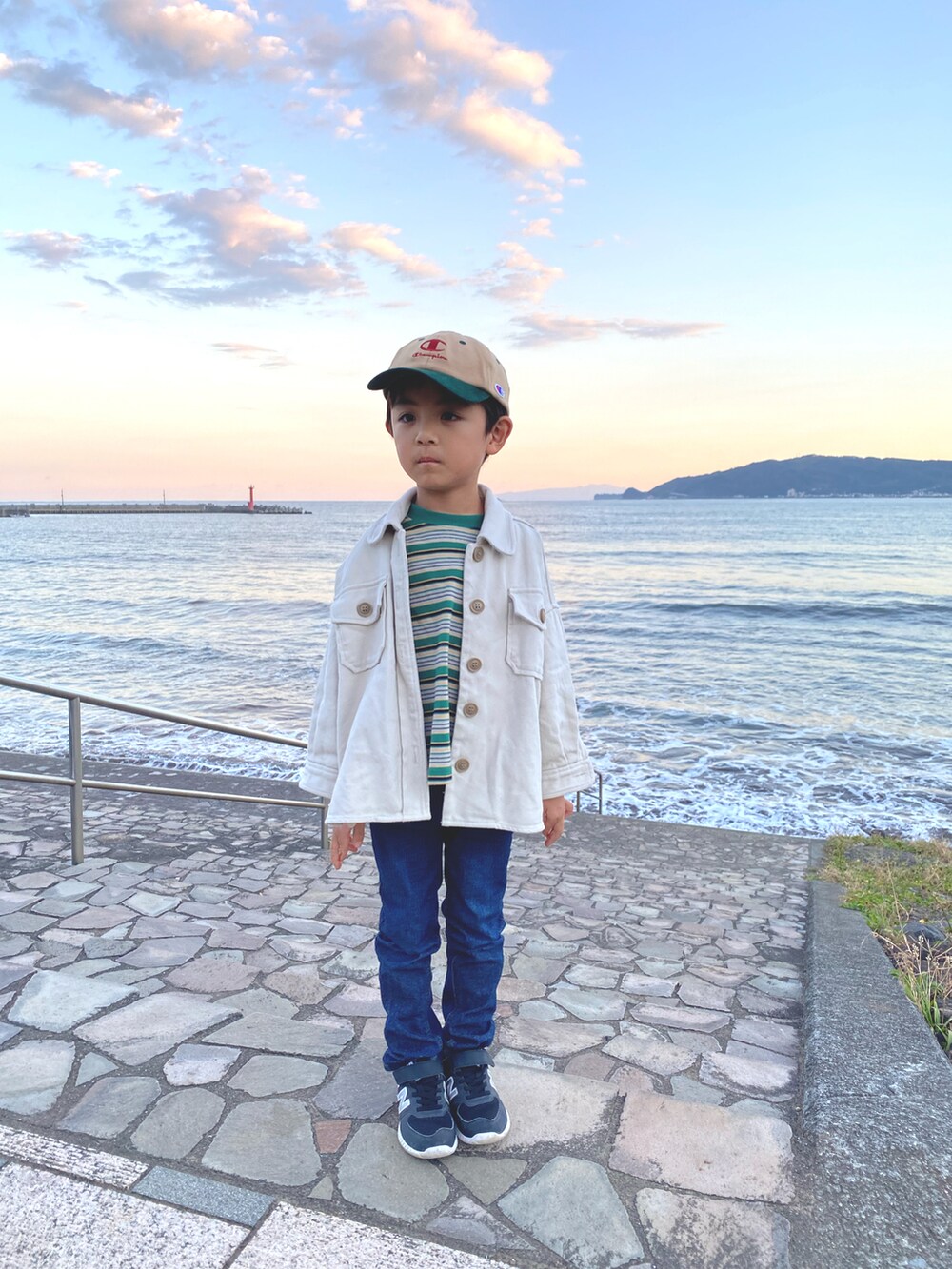 ホワイト系のブルゾン、ブルー系のデニムパンツ、グリーン系のTシャツ/カットソーを着用したキッズの秋コーディネートの2枚目の写真