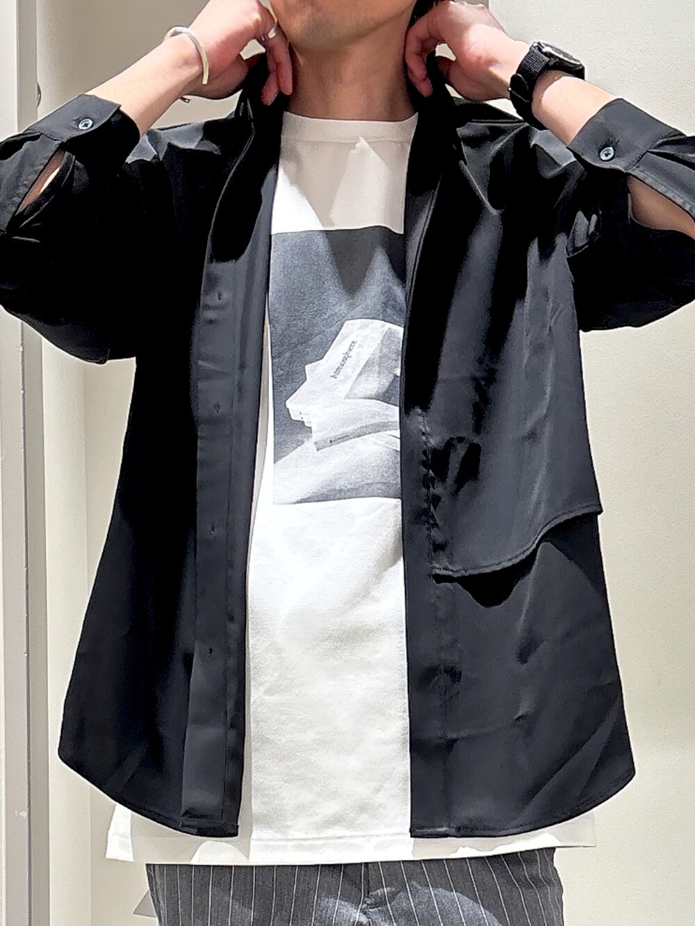 ブラック系のシャツ/ブラウス、グレー系のスラックス、ホワイト系のTシャツ/カットソーを着用したメンズの春コーディネートの4枚目の写真