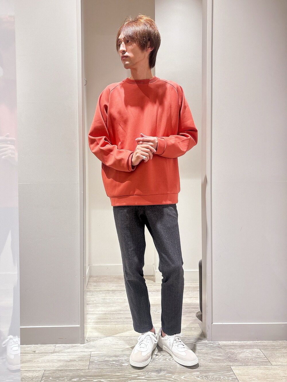 オレンジ系のスウェット、ブルー系のデニムジャケット、ブラック系のスラックスを着用したメンズの秋コーディネートの4枚目の写真