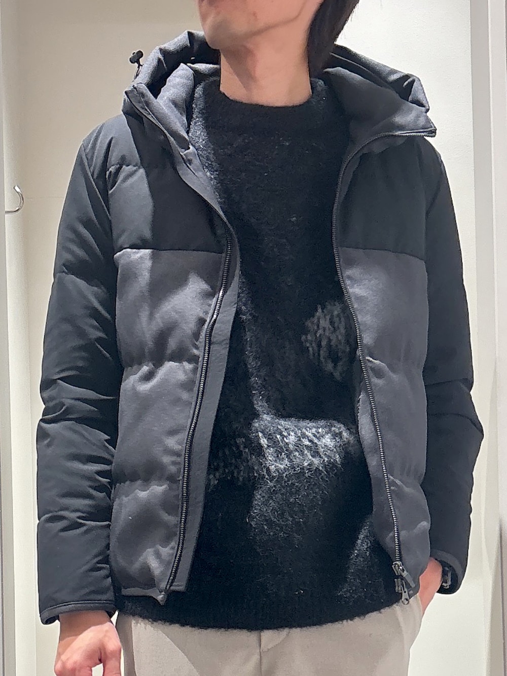 グレー系のダウンジャケット/コート、グレー系のニット/セーター、ベージュ系のスラックスを着用したメンズの冬コーディネートの4枚目の写真