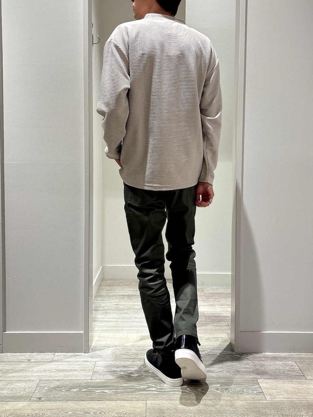 ベージュ系のTシャツ/カットソー、ブラック系のバックパック/リュック、グリーン系のチノパンツを着用したメンズの秋コーディネートの3枚目の写真