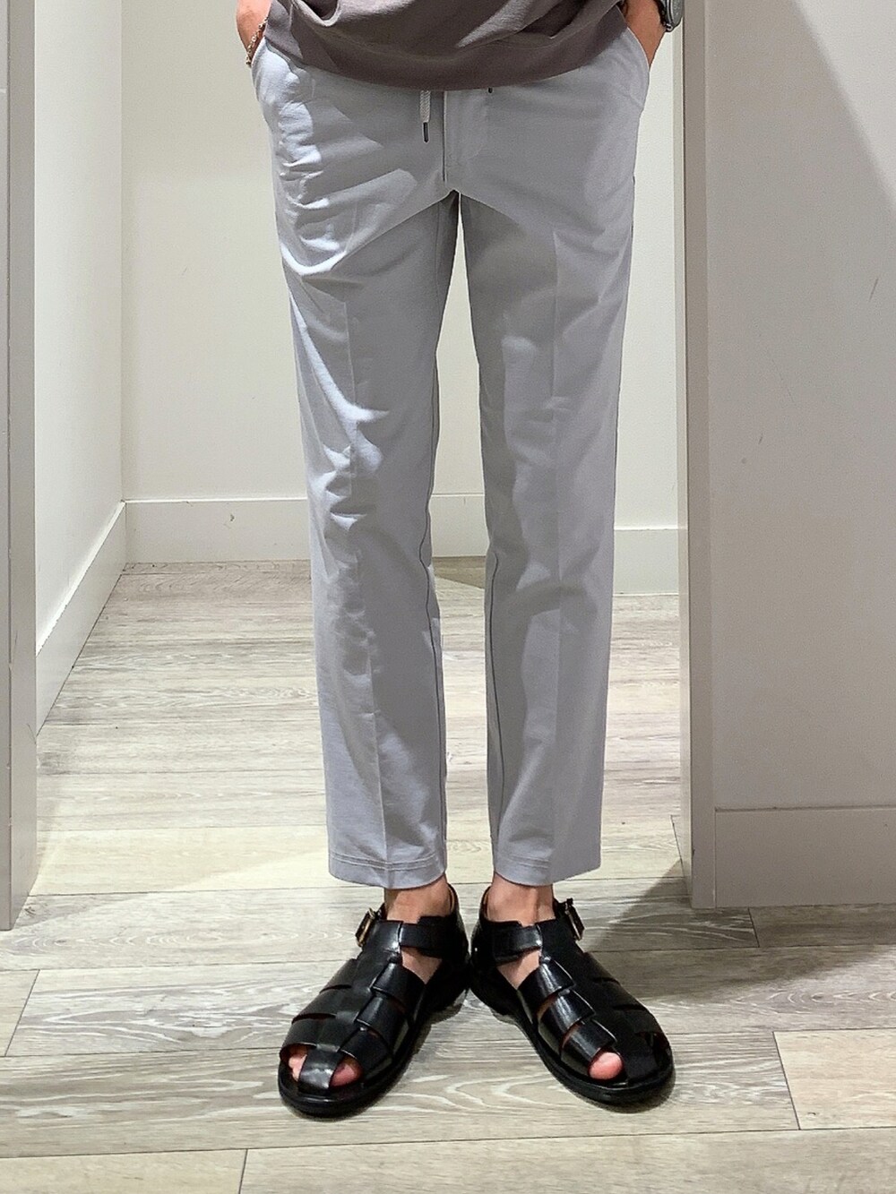 ブラウン系のTシャツ/カットソー、ブラック系のボディバッグ/ウエストポーチ、グレー系のスラックスを着用したメンズの夏コーディネートの5枚目の写真