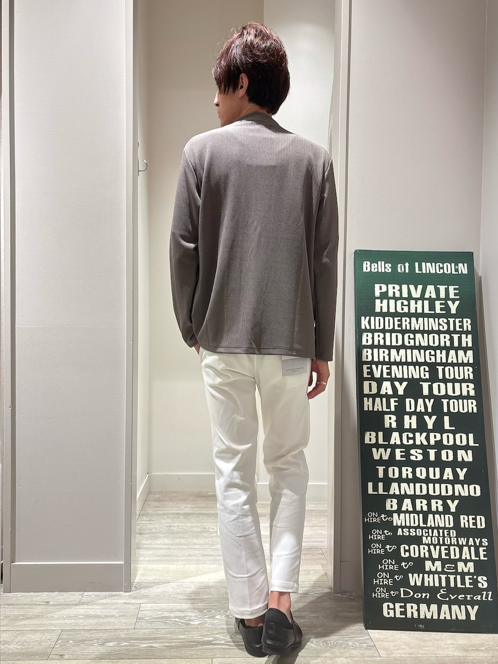 ブラック系のTシャツ/カットソー、ホワイト系のスラックス、ブラック系のカーディガン/ボレロを着用したメンズの秋コーディネートの3枚目の写真