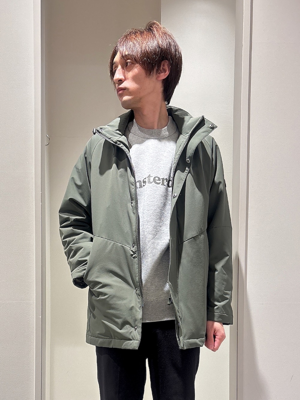 グリーン系のブルゾン、ブラック系のスラックス、グレー系のニット/セーターを着用したメンズの春コーディネートの4枚目の写真