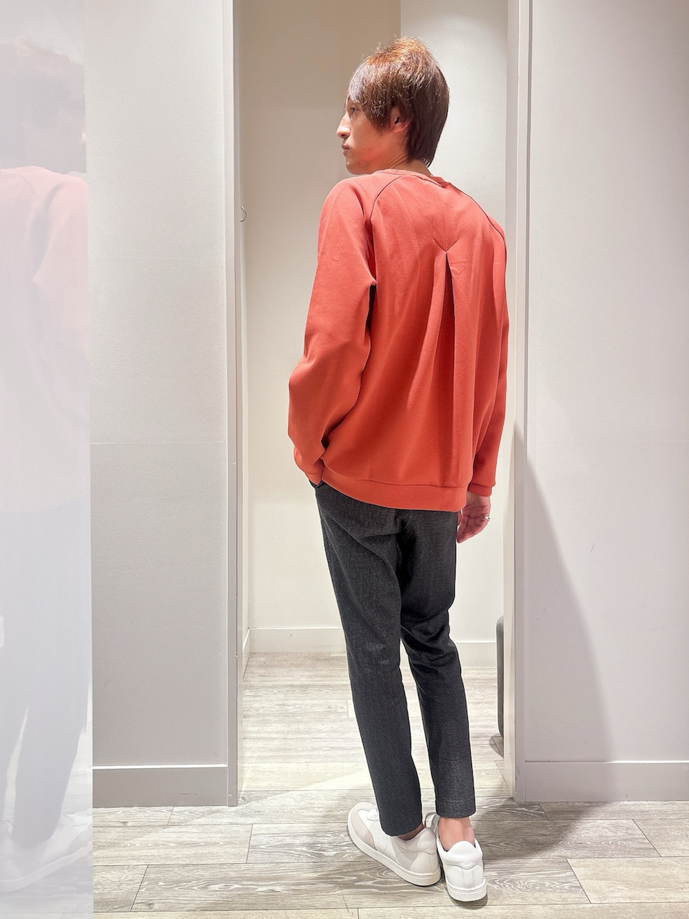 オレンジ系のスウェット、ブルー系のデニムジャケット、ブラック系のスラックスを着用したメンズの秋コーディネートの5枚目の写真