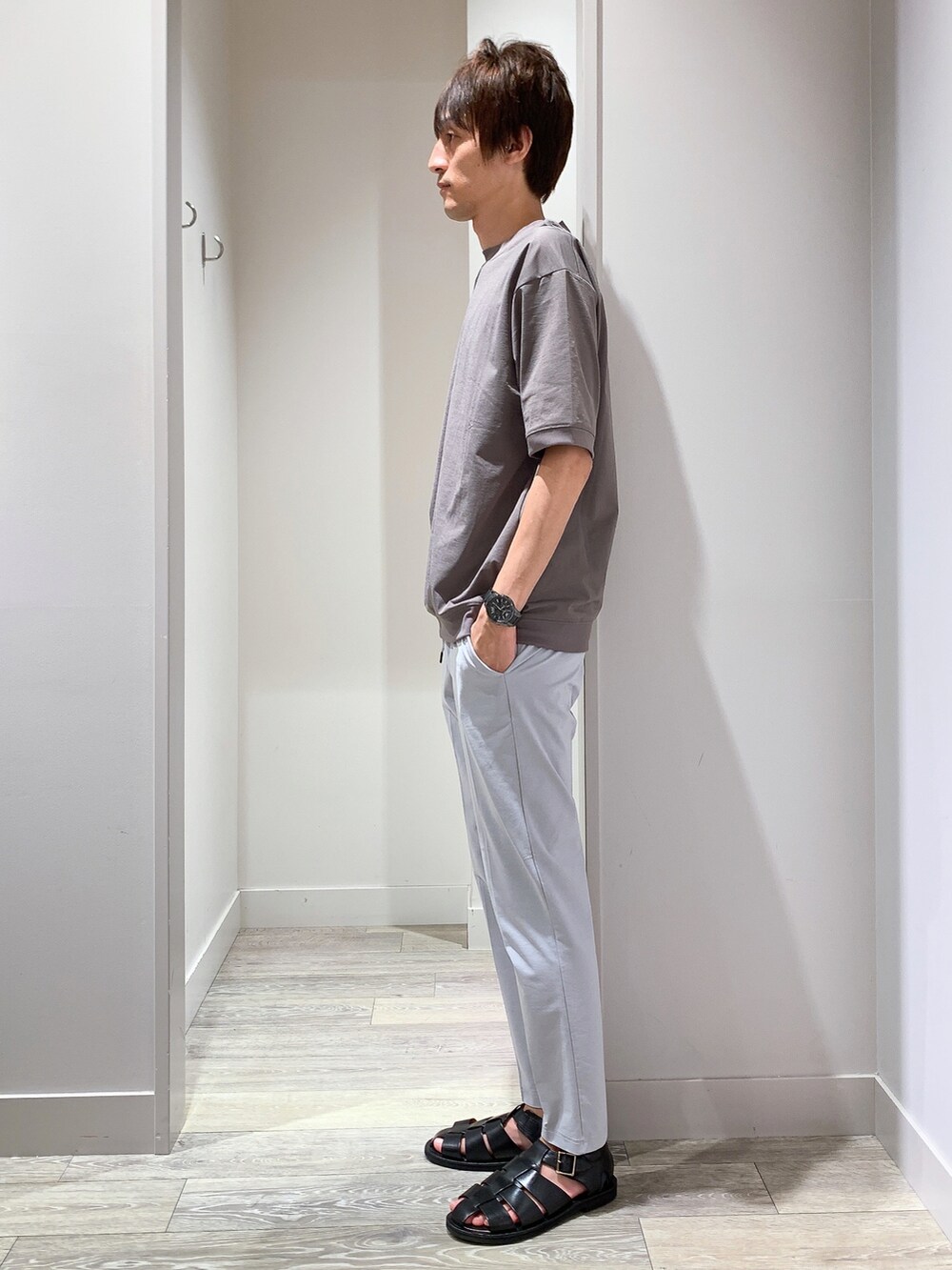 ブラウン系のTシャツ/カットソー、ブラック系のボディバッグ/ウエストポーチ、グレー系のスラックスを着用したメンズの夏コーディネートの2枚目の写真