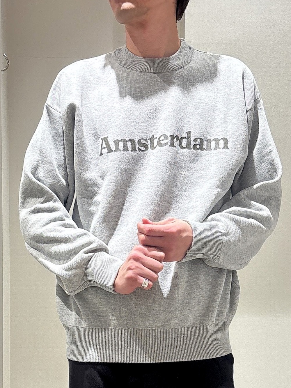 グリーン系のブルゾン、ブラック系のスラックス、グレー系のニット/セーターを着用したメンズの春コーディネートの5枚目の写真