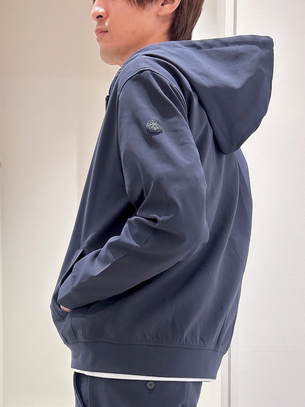 ブルー系のパーカー、ホワイト系のTシャツ/カットソー、ブルー系のスラックスを着用したメンズの秋コーディネートの4枚目の写真