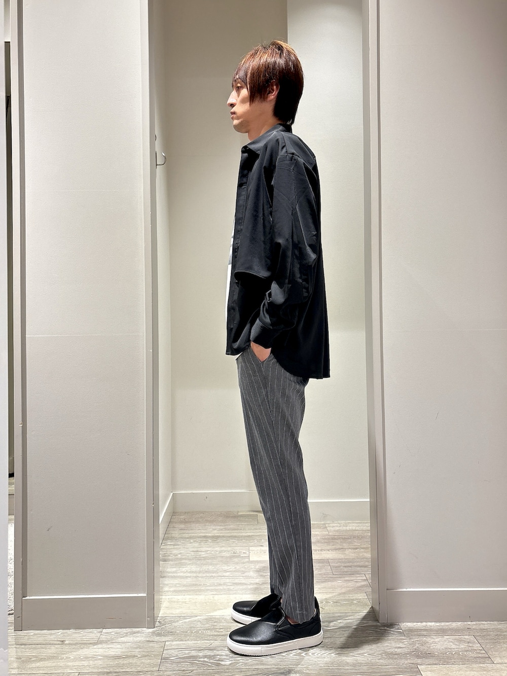 ブラック系のシャツ/ブラウス、グレー系のスラックス、ホワイト系のTシャツ/カットソーを着用したメンズの春コーディネートの2枚目の写真