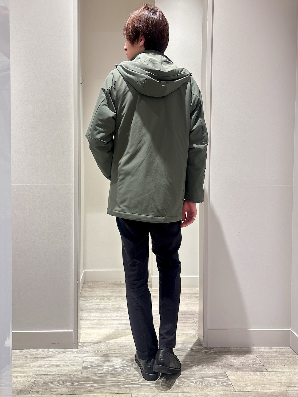 グリーン系のブルゾン、ブラック系のスラックス、グレー系のニット/セーターを着用したメンズの春コーディネートの3枚目の写真