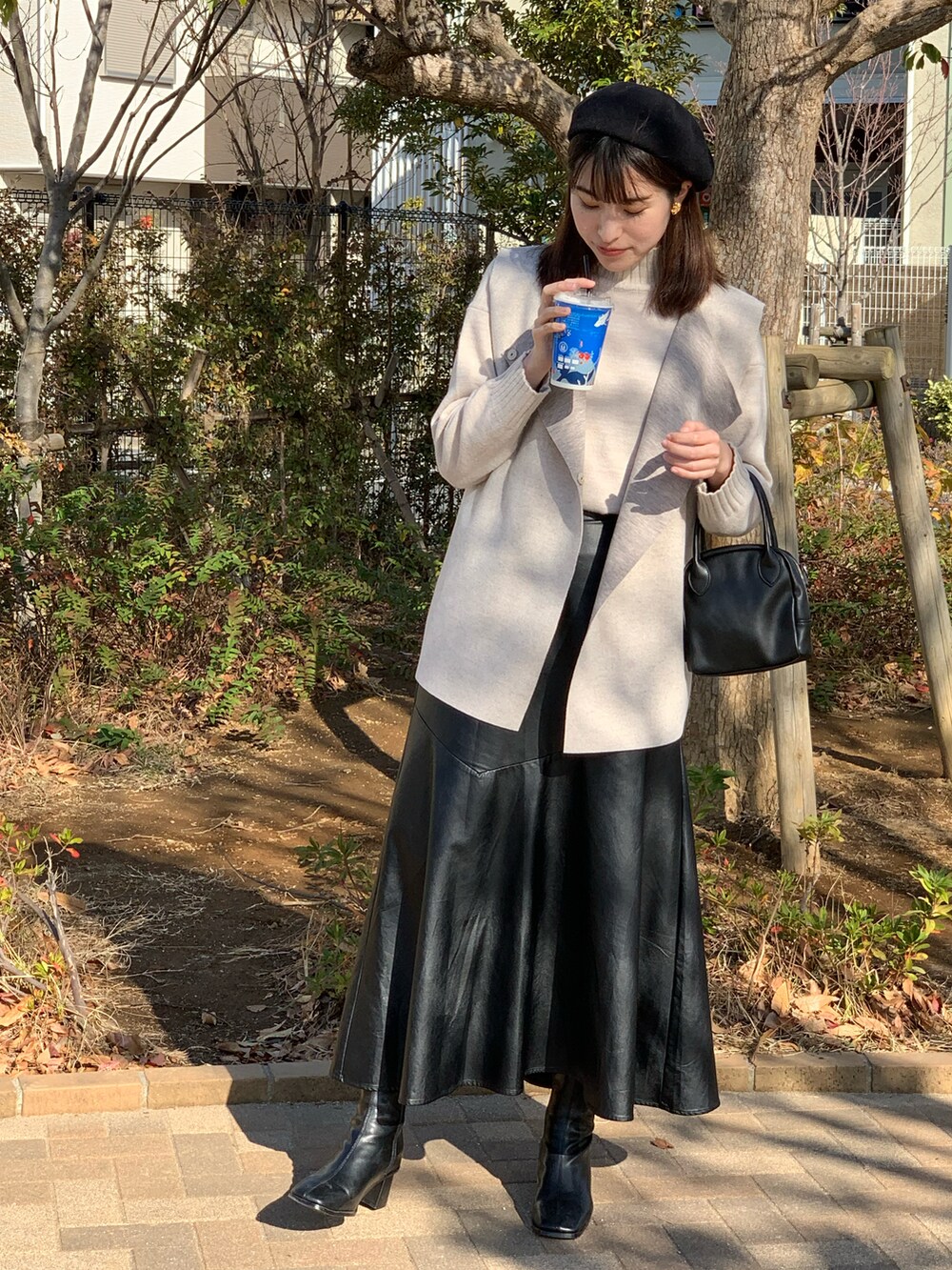 ベージュ系のその他アウター、ブラック系のボストンバッグ、ホワイト系のニット/セーターを着用したレディースの冬コーディネートの2枚目の写真