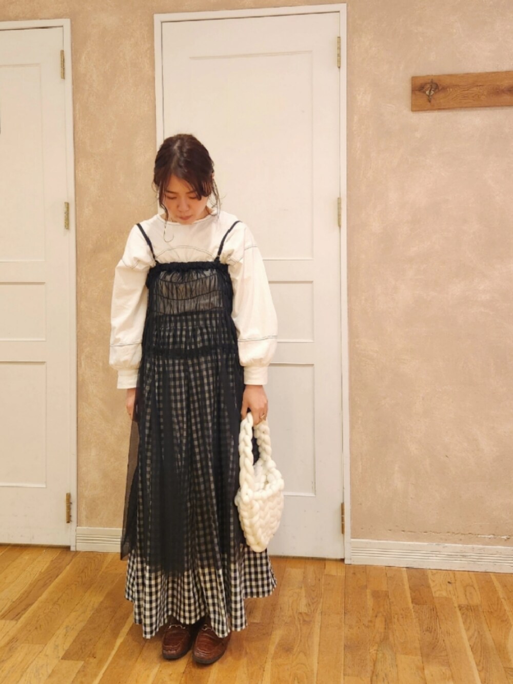 ブラック系のスカート、ホワイト系のバッグ、ホワイト系のスカートを着用したレディースの秋コーディネートの2枚目の写真