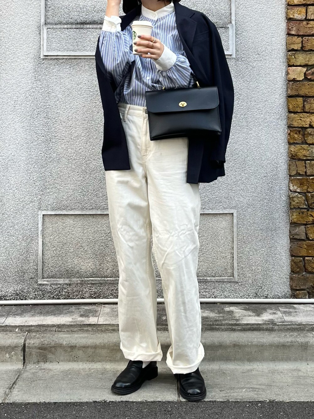 ブラック系のショルダーバッグ、ブルー系のテーラードジャケット、ブルー系のシャツ/ブラウスを着用したレディースの冬コーディネートの2枚目の写真