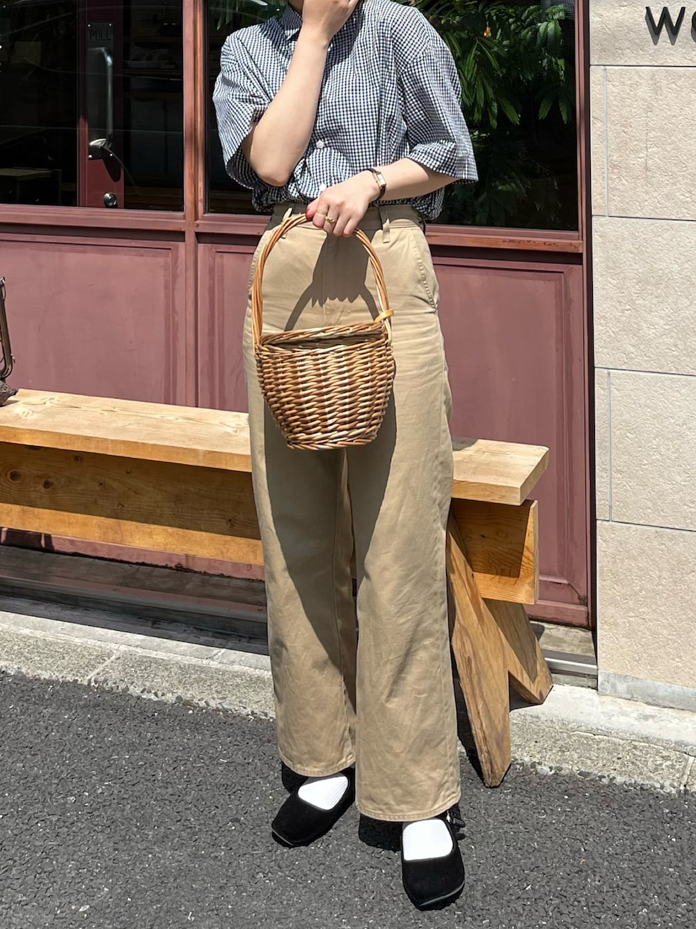 ブラック系のバレエシューズ、ブラック系のチノパンツ、ベージュ系のかごバッグを着用したレディースの春コーディネートの2枚目の写真