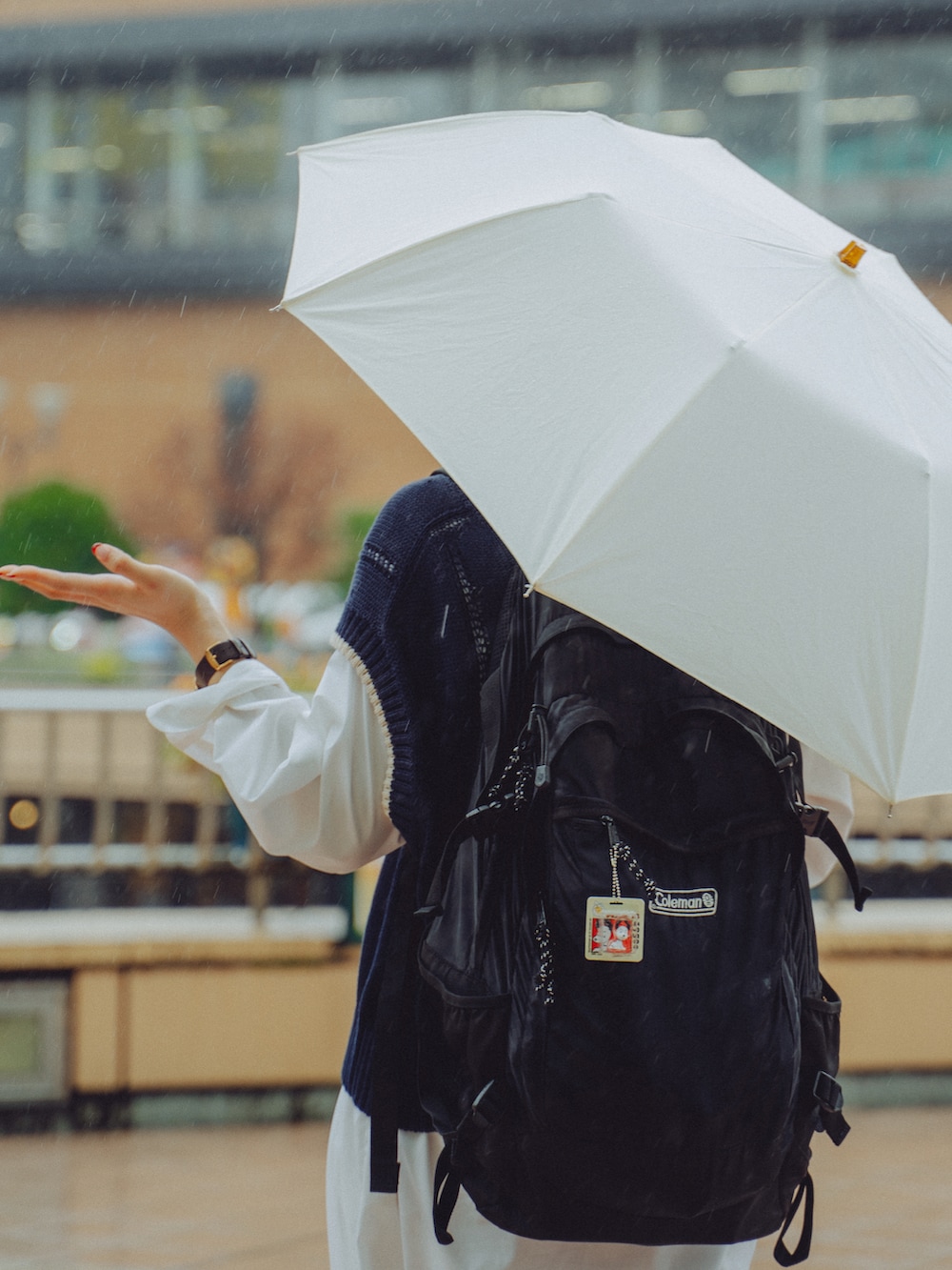 ホワイト系のワンピース/ドレス、ブルー系のニット/セーター、ホワイト系の折りたたみ傘を着用したレディースの秋コーディネートの2枚目の写真