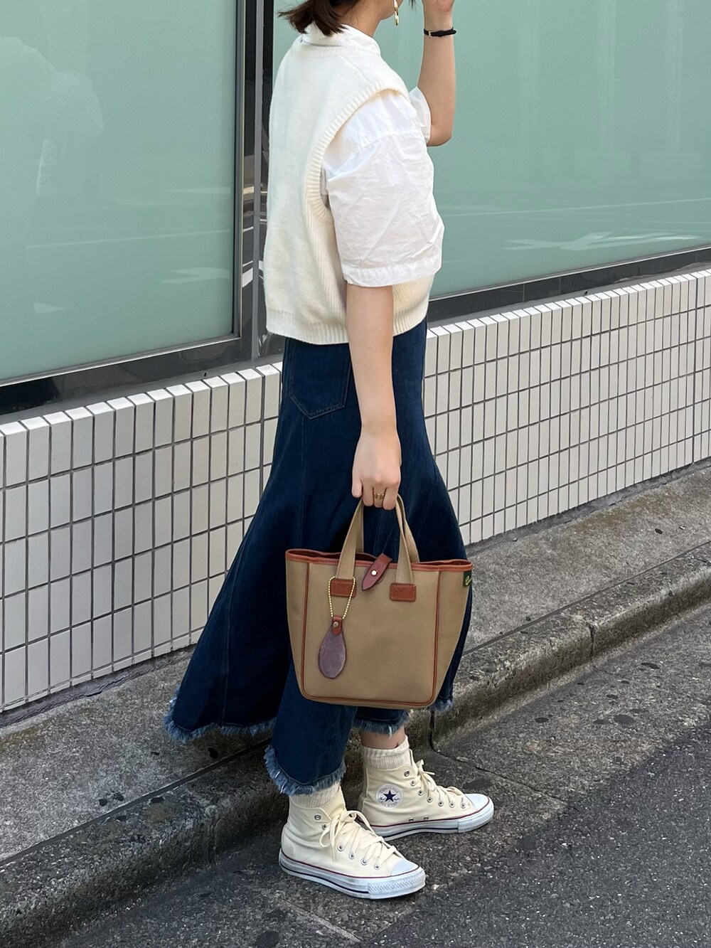 グリーン系のトートバッグ、ホワイト系のシャツ/ブラウス、ブルー系のスカートを着用したレディースの夏コーディネートの2枚目の写真