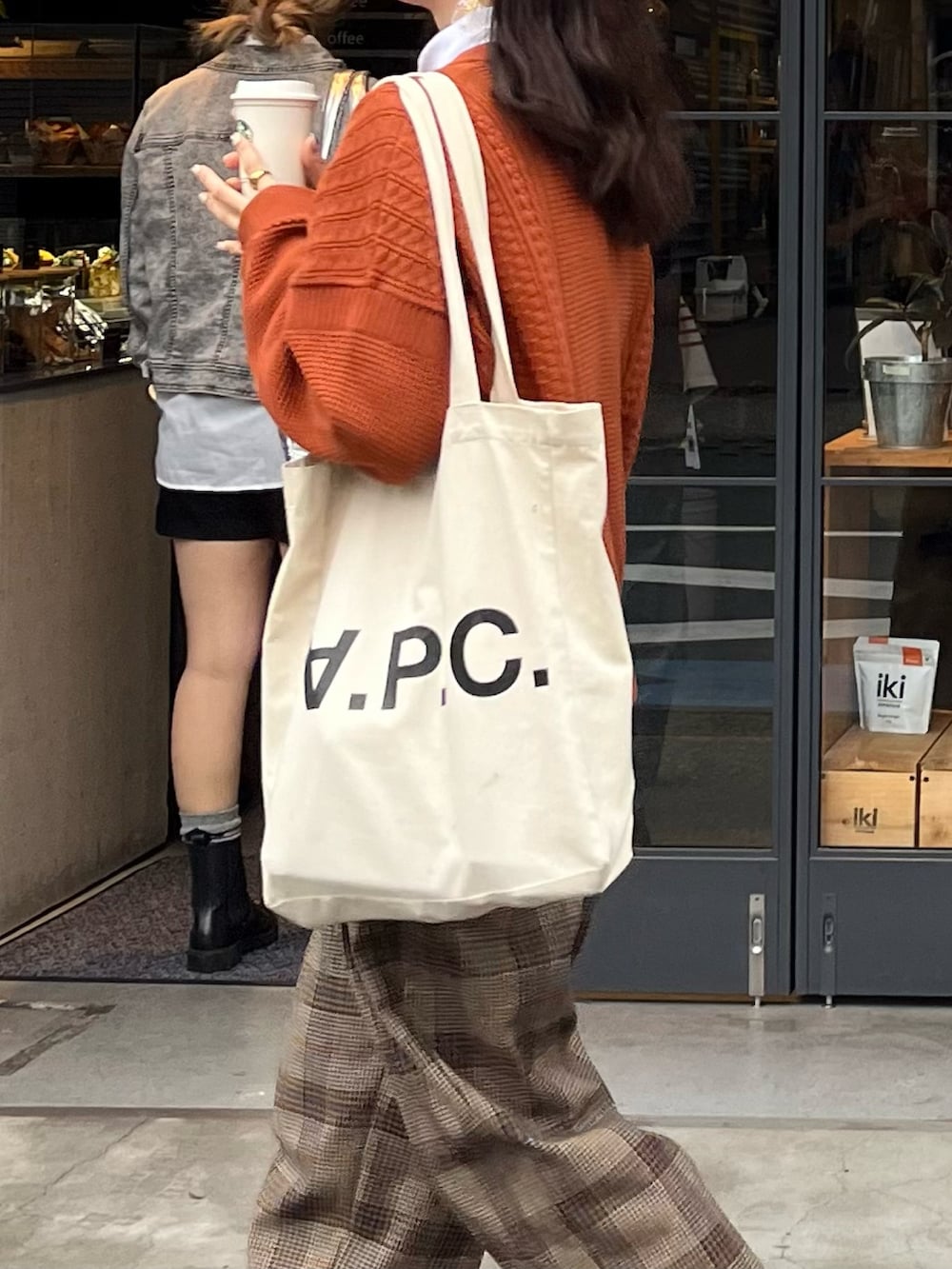 ブラウン系のドレスシューズ、ブラウン系のスラックス、ホワイト系のトートバッグを着用したレディースの秋コーディネートの2枚目の写真