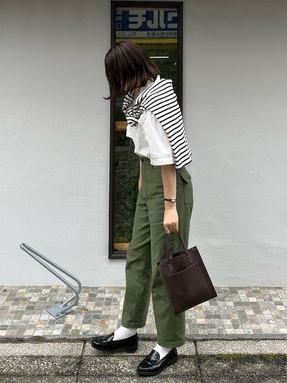 グリーン系のその他パンツ、ブラウン系のショルダーバッグ、ホワイト系のシャツ/ブラウスを着用したレディースの春コーディネートの2枚目の写真