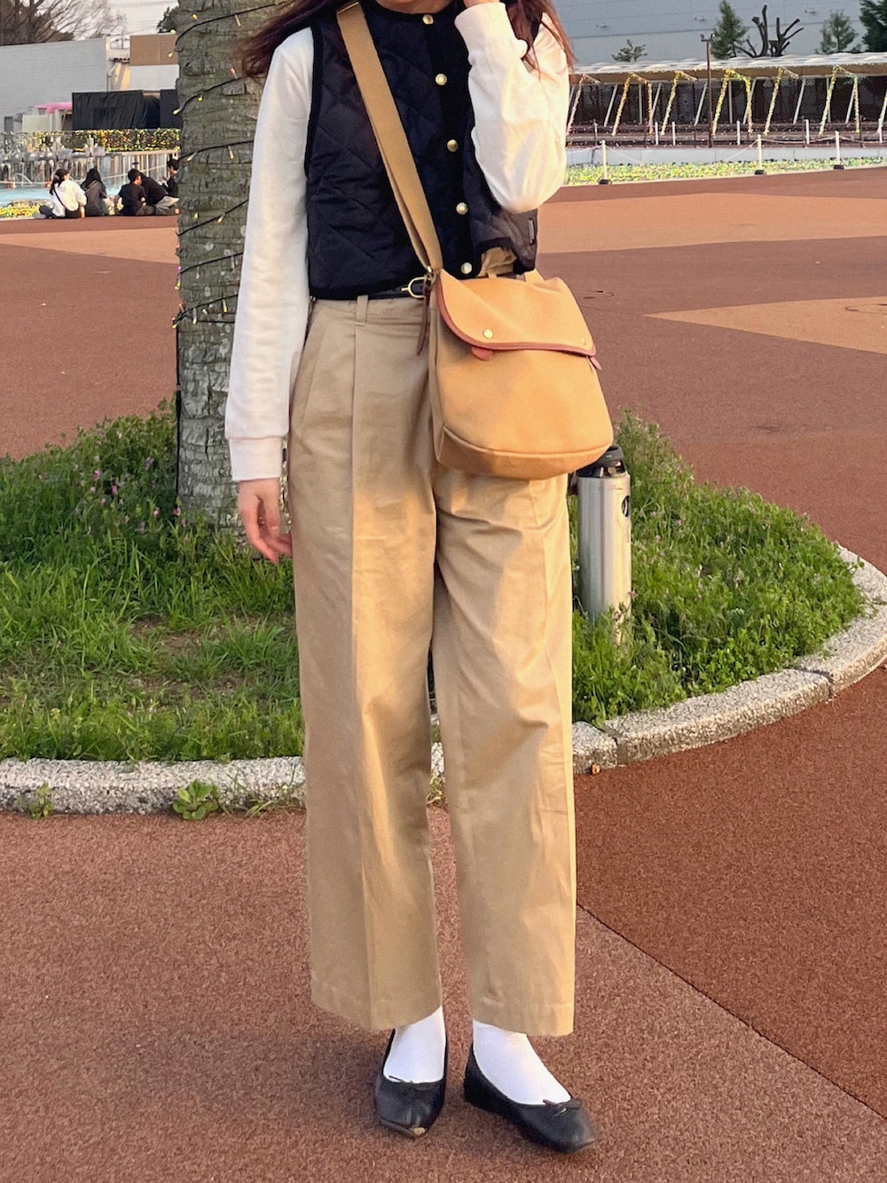 ブラック系のバレエシューズ、ブラック系のその他アウター、ホワイト系のTシャツ/カットソーを着用したレディースの春コーディネートの2枚目の写真