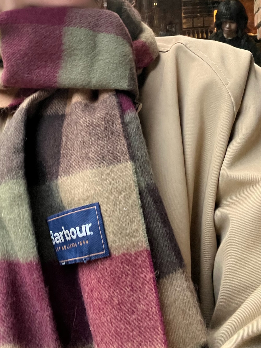 ブラウン系のドレスシューズ、ブラウン系のスカート、レッド系のショルダーバッグを着用したレディースの冬コーディネートの2枚目の写真