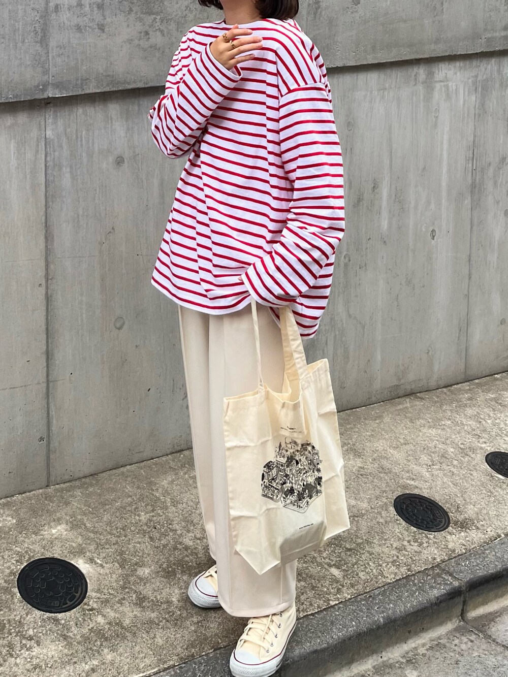 レッド系のトップス、ホワイト系のバッグ、ホワイト系のその他パンツを着用したレディースの春コーディネートの3枚目の写真