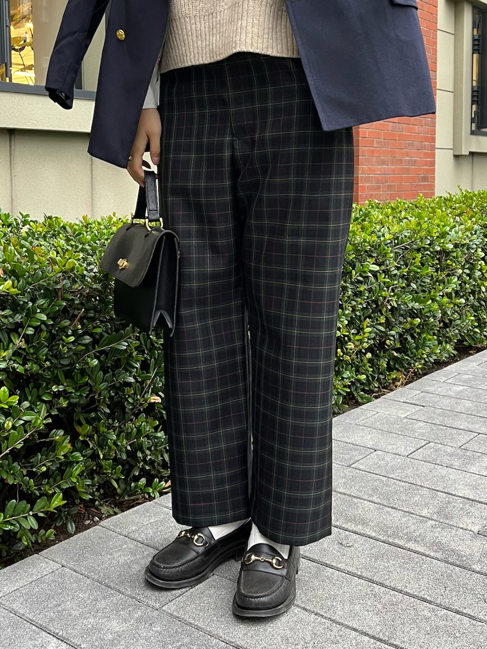 グリーン系のパンツ、ブラック系のショルダーバッグ、ベージュ系のベストを着用したレディースの秋コーディネートの2枚目の写真