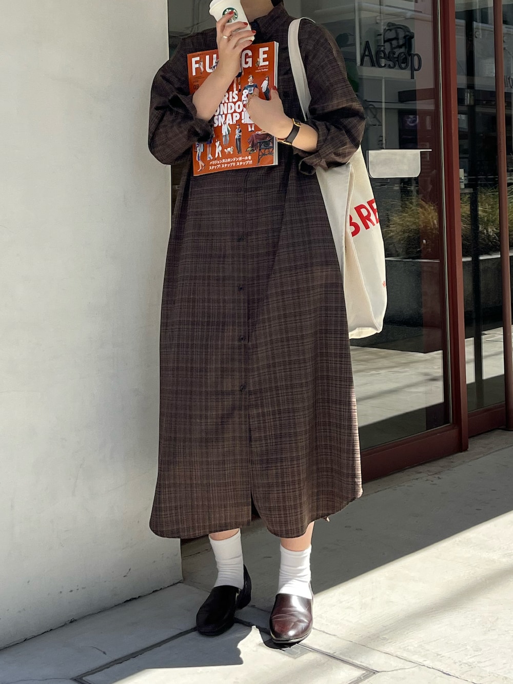 その他のトートバッグ、ブラック系のシャツワンピース、ブラウン系のドレスシューズを着用したレディースの秋コーディネートの2枚目の写真