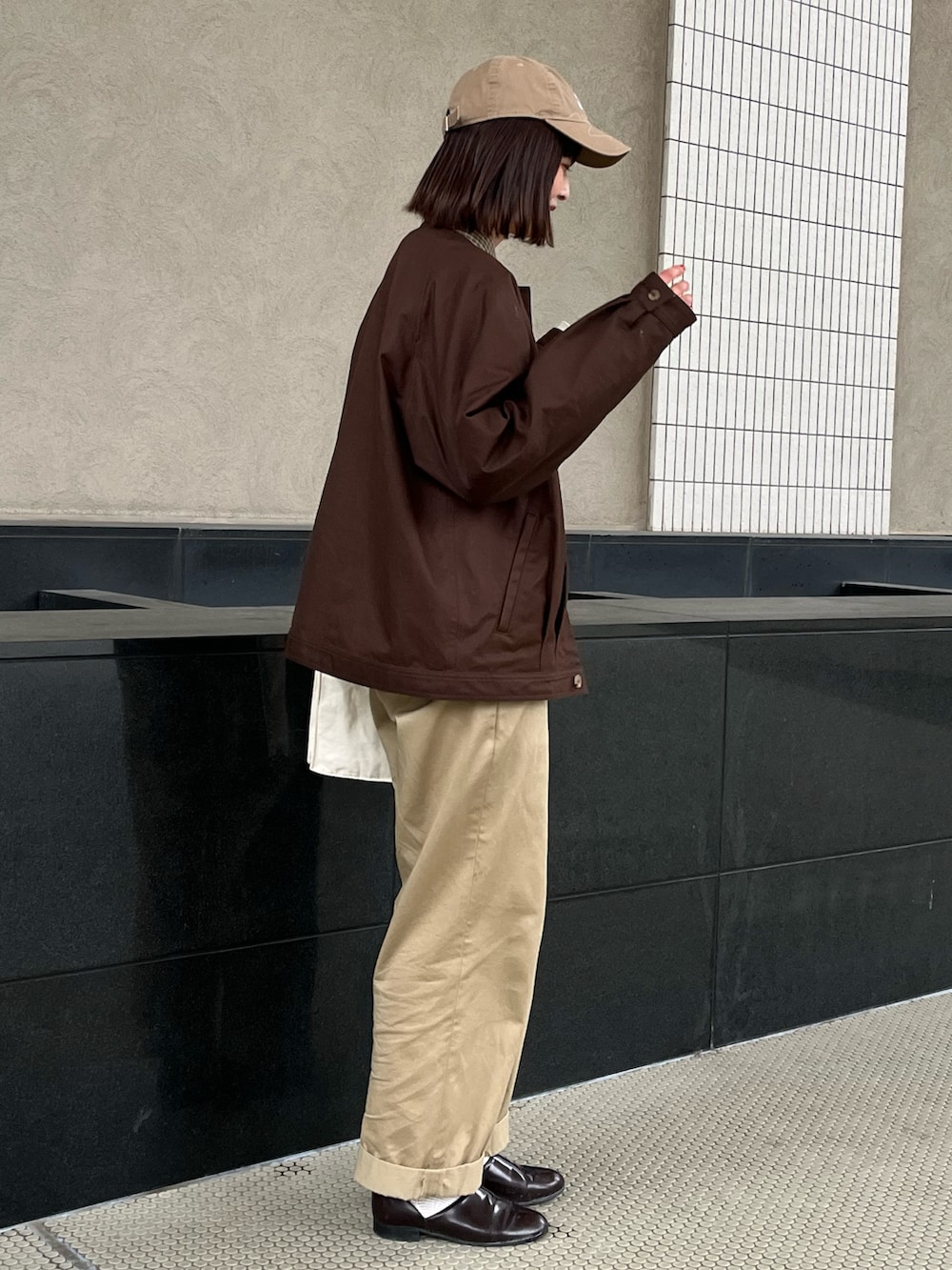 ブラウン系のブルゾン、ベージュ系のスウェット、ベージュ系のチノパンツを着用したレディースの冬コーディネートの2枚目の写真