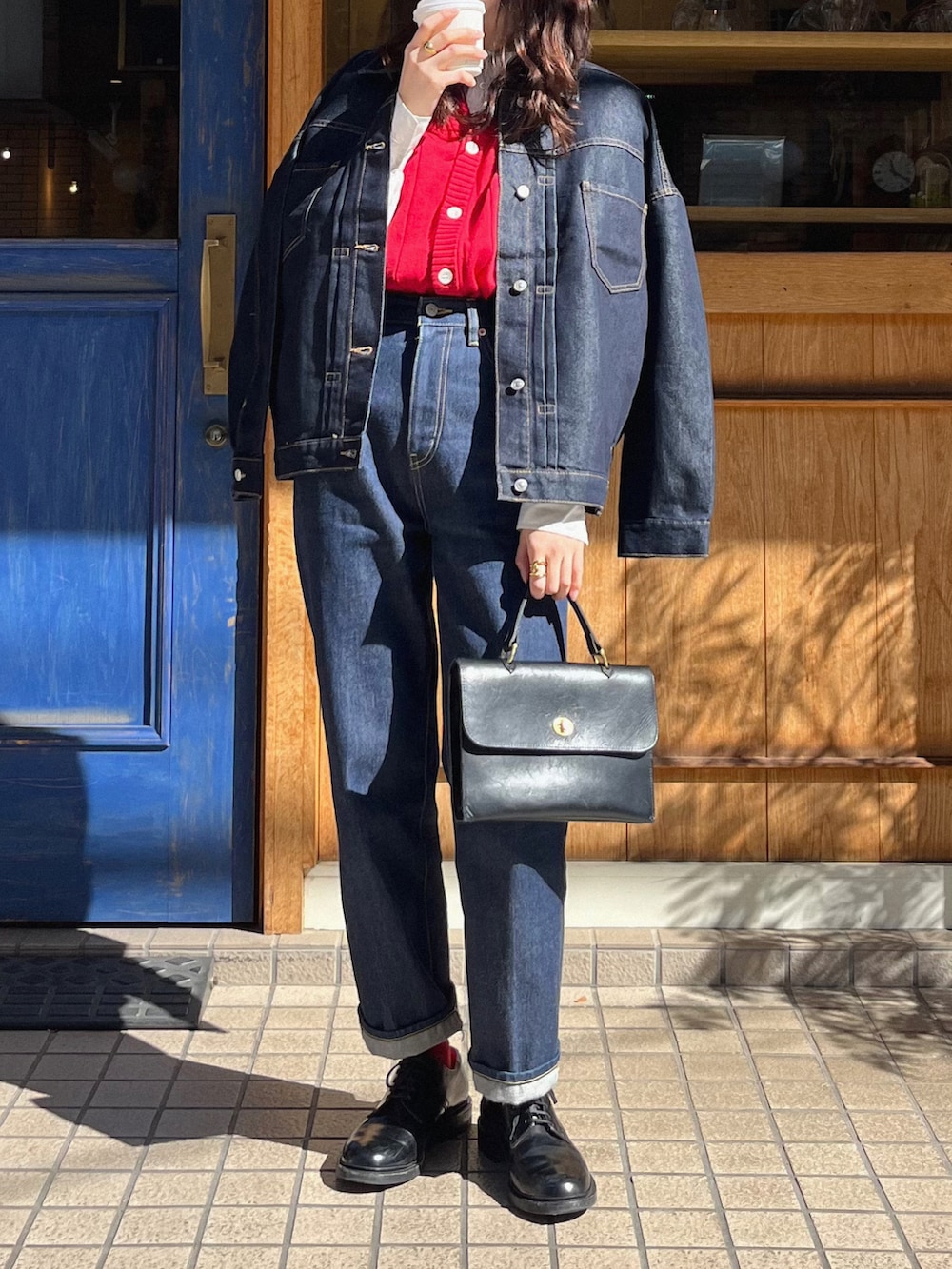 ブルー系のデニムパンツ、ブラック系のショルダーバッグ、ブルー系のデニムジャケットを着用したレディースの冬コーディネートの2枚目の写真