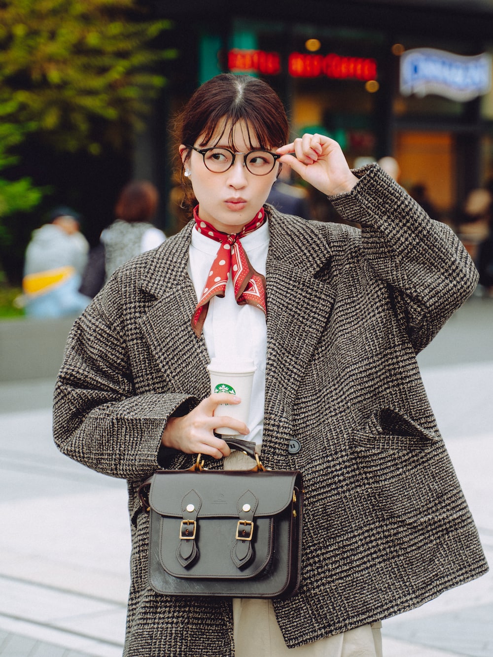 ブラウン系のブーツ、ブラウン系のショルダーバッグ、ベージュ系のスカートを着用したレディースの秋コーディネートの2枚目の写真