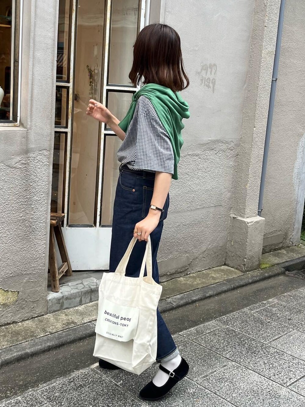 ホワイト系のトートバッグ、ブラック系のシャツ/ブラウス、グリーン系のカーディガン/ボレロを着用したレディースの夏コーディネートの2枚目の写真