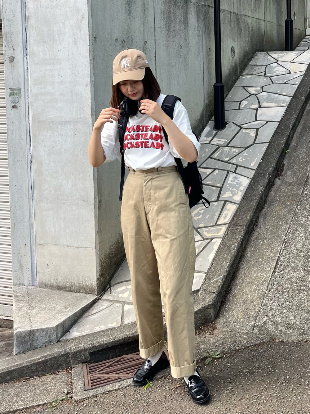 ベージュ系のチノパンツ、ホワイト系のTシャツ/カットソー、ブラック系のローファーを着用したレディースの夏コーディネートの2枚目の写真