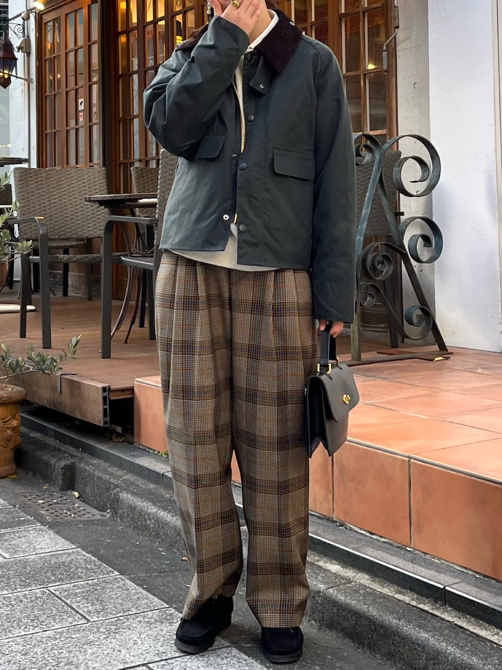 ブラウン系のスラックス、グリーン系のブルゾン、ブラック系のショルダーバッグを着用したレディースの冬コーディネートの2枚目の写真