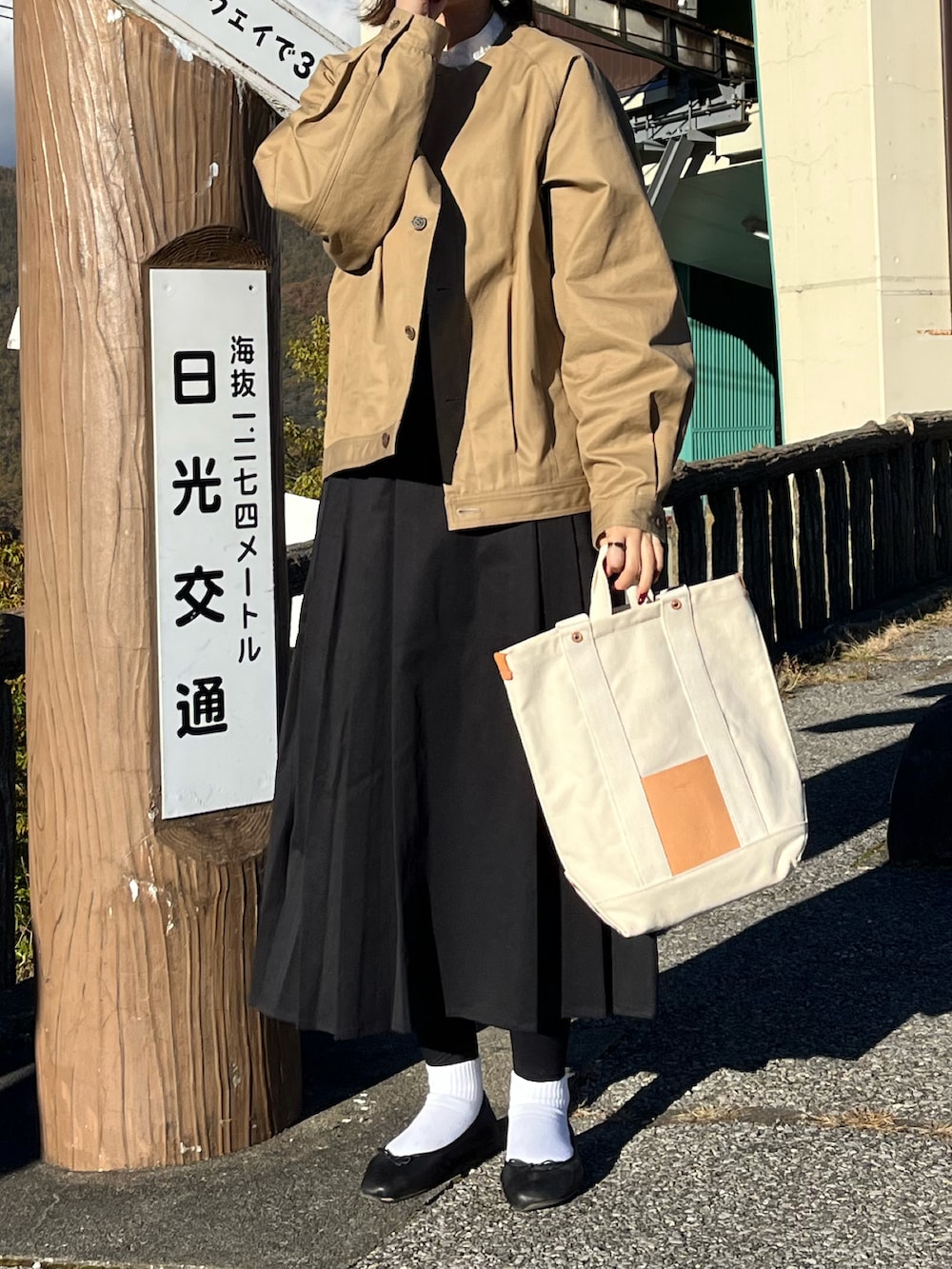 ベージュ系のトートバッグ、ホワイト系のシャツ/ブラウス、ブラック系のバレエシューズを着用したレディースの秋コーディネートの2枚目の写真