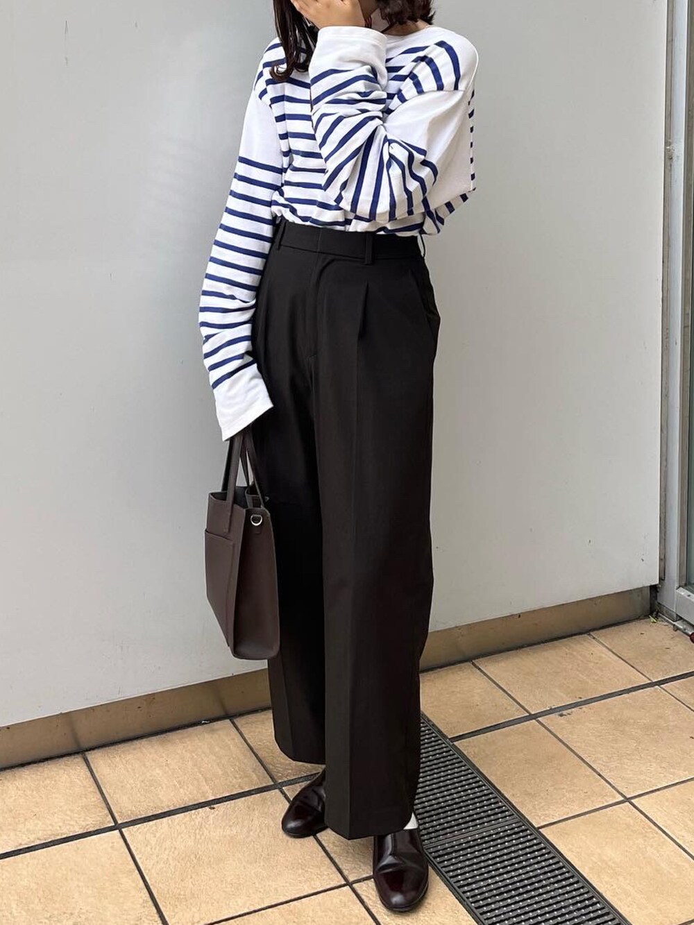 ブラウン系のパンツ、ブラウン系のショルダーバッグ、ブラウン系のドレスシューズを着用したレディースの秋コーディネートの2枚目の写真