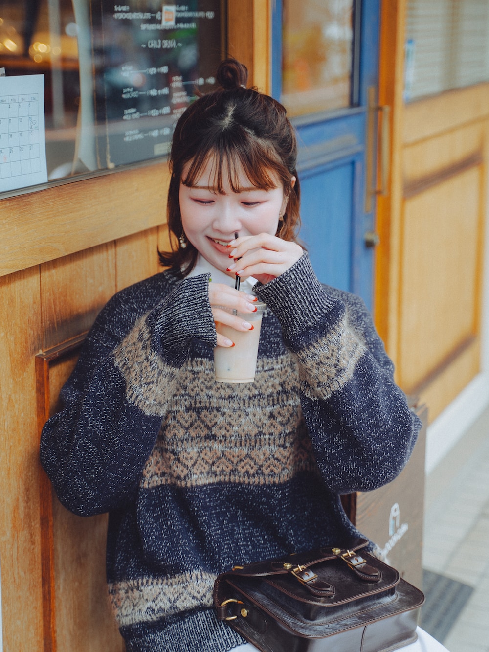 ブラック系のワンピース/ドレス、ブラウン系のブーツ、ブラウン系のショルダーバッグを着用したレディースの秋コーディネートの3枚目の写真