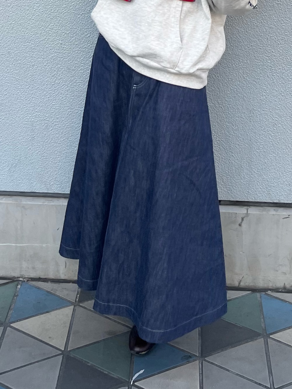 ブルー系のスカート、ブラウン系のドレスシューズを着用したレディースの冬コーディネートの3枚目の写真