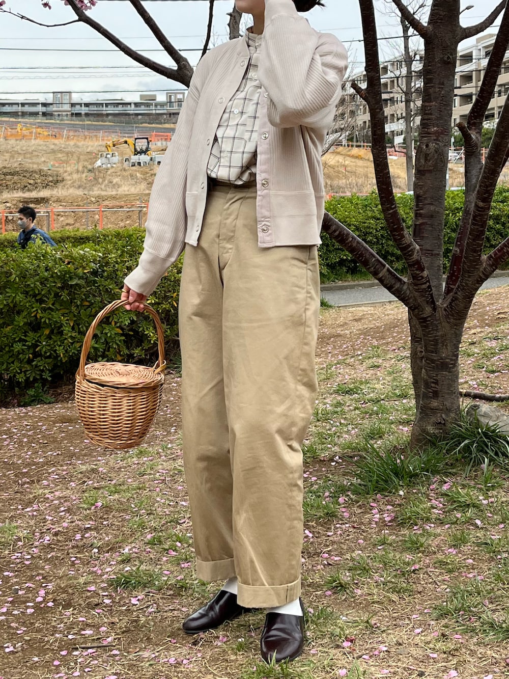 ホワイト系のカーディガン/ボレロ、ベージュ系のかごバッグ、ブラウン系のドレスシューズを着用したレディースの春コーディネートの2枚目の写真