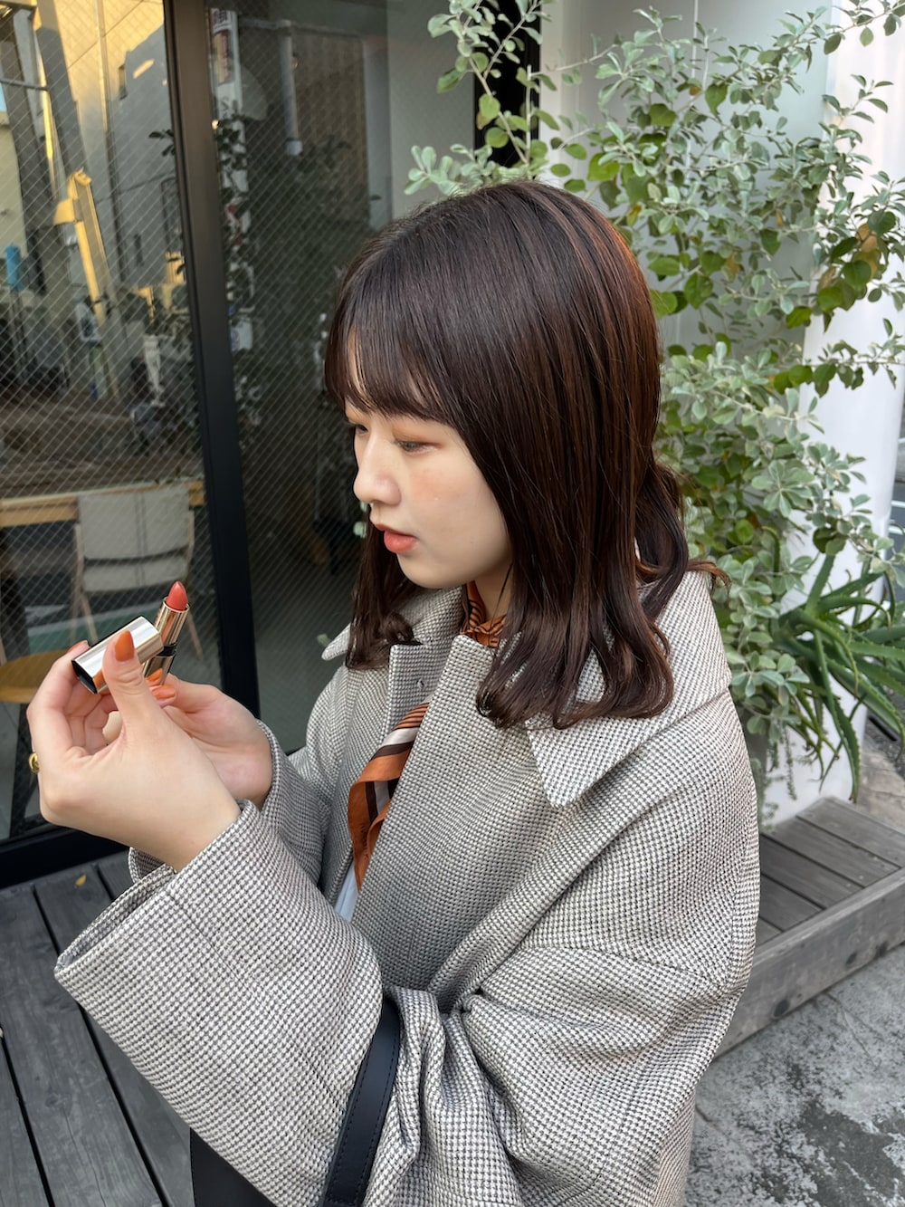 ブラウン系のステンカラーコート、ブラック系のショルダーバッグ、ブラック系のドレスシューズを着用したレディースの秋コーディネートの2枚目の写真