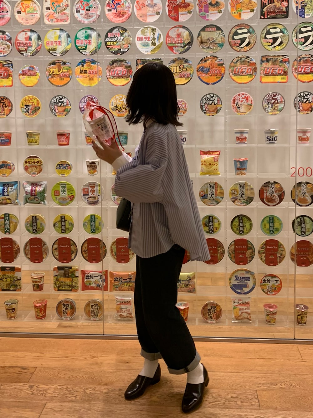 ブルー系のシャツ/ブラウス、ブルー系のデニムパンツ、ブラック系のハンドバッグを着用したレディースの春コーディネートの5枚目の写真