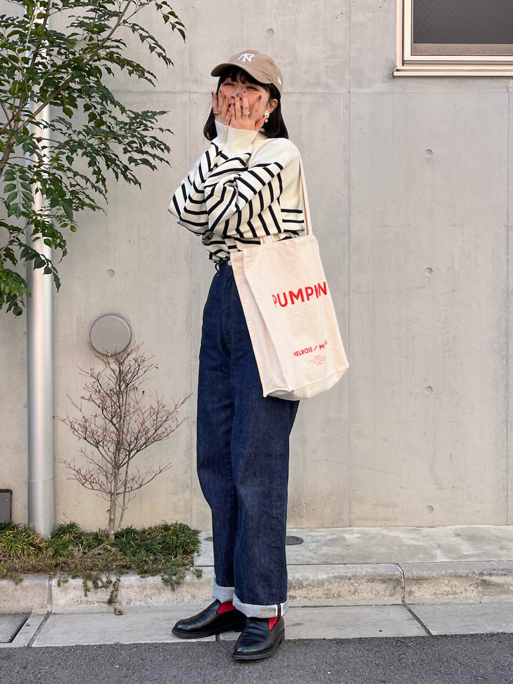 ブルー系のデニムパンツ、ブラック系のドレスシューズ、ホワイト系のニット/セーターを着用したレディースの冬コーディネートの2枚目の写真