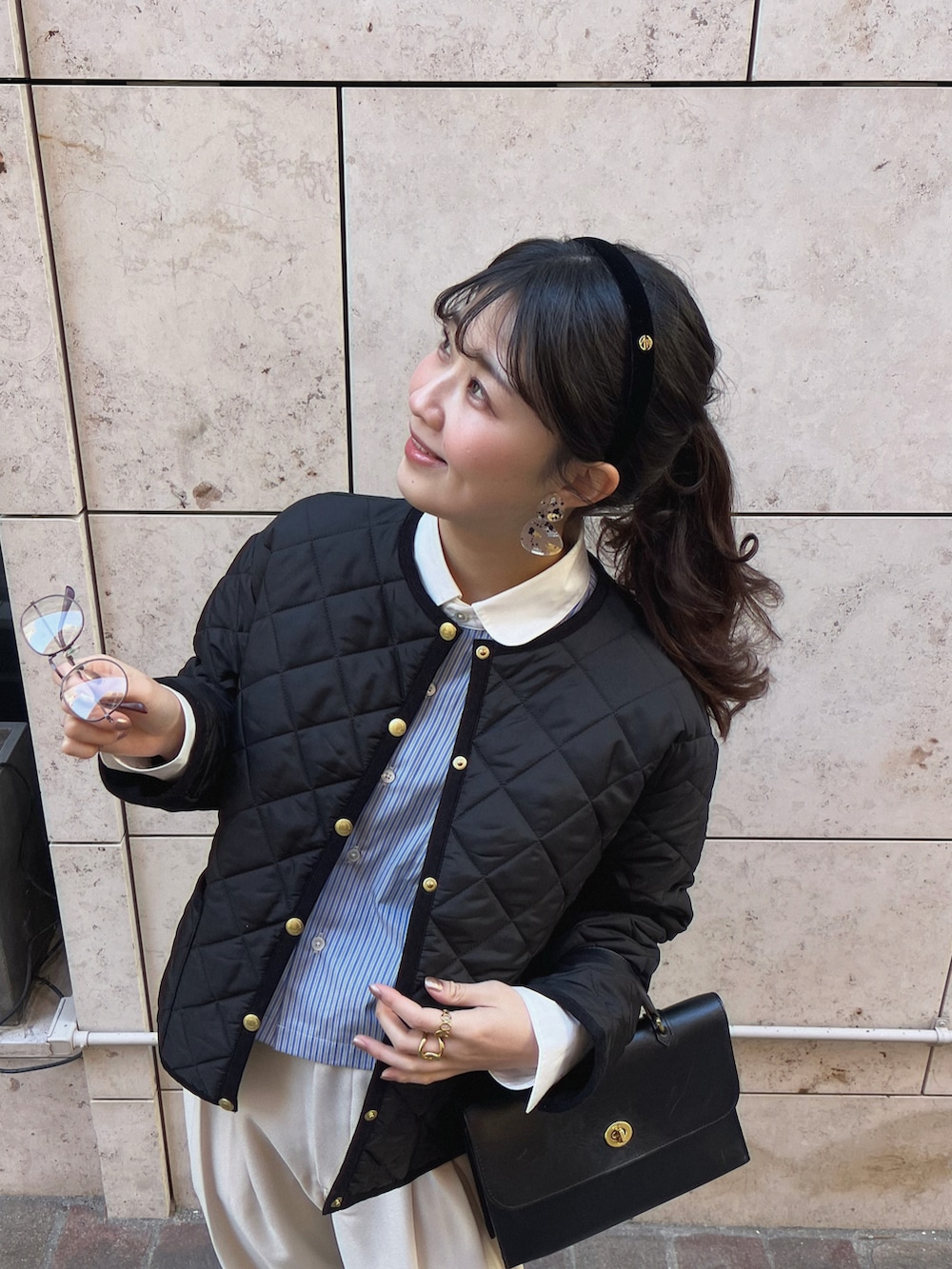 ブラック系のショルダーバッグ、ホワイト系のその他パンツ、ブラック系のその他アウターを着用したレディースの冬コーディネートの3枚目の写真